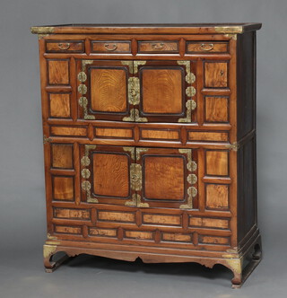 A 19th Century Korean hardwood cabinet fitted 3 short drawers above cupboard enclosed by a panelled door, the base fitted a cupboard enclosed by panelled door, raised on shaped supports with gilt metal mounts 134cm h x 113cm w x 51cm d 