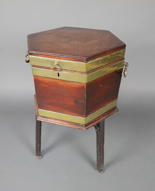 A Georgian hexagonal brass banded mahogany wine cooler with lid and fitted interior, raised on original base with 3 outswept reeded supports ending in brass caps and casters, 70cm h x 47cm x 41cm  