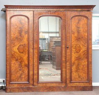 A Victorian figured walnut triple wardrobe with moulded cornice, 1 section fitted 3 drawers above 3 drawers with brass swan neck drop handles, the centre section with hanging space above 1 long drawer, enclosed by an arched panelled door and panelled door 206cm h x 222cm w x 67cm d 