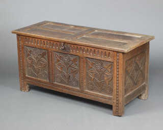 A mid 17th Century carved oak coffer of panelled construction, the hinged lid with iron butterfly hinges, the interior fitted a candle box, the frieze fluted, the front panels carved flowers 59cm h x 121cm w x 51cm d 