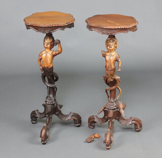 A pair of 19th Century carved limewood torcheres the tops of serpentine outline above figures of cherubs with grapes, raised on pillar and tripod bases 66cm h x 31cm x 28cm 