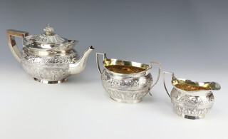 A Victorian repousse silver tea set comprising teapot, sugar bowl and milk jug decorated with flowers, London 1896 and 1897 Maker Charles Stuart Harris gross weight 1169 grams 