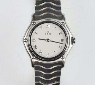 A lady's Ebel Mini Wave stainless steel quartz wristwatch contained in a 22mm case numbered 11553337 9057901 on a ditto bracelet with spare link, original pouch, warranty card dated 1998  booklet and box 