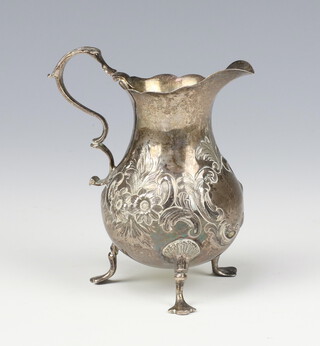 A Georgian silver repousse cream jug with shell knees and pad feet, rubbed marks, 75 grams