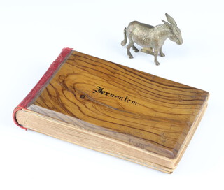 A metal novelty tape measure in the form of a donkey with winder tail together with a Jerusalem olive wood album of pressed flowers 