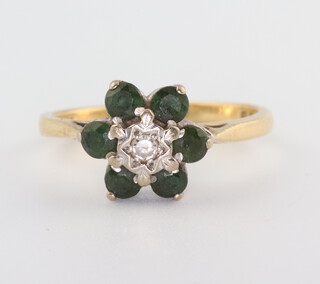 An 18ct yellow gold tourmaline and diamond cluster ring, the 6 tourmalines each approx. 0.15ct, the illusion set diamond approx. 0.05ct, 3.4 grams  Size M 1/2