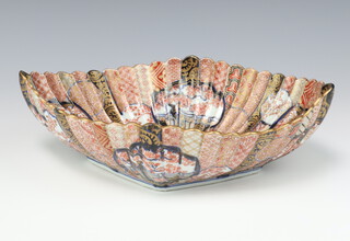 A Japanese Imari fluted oval dish, Meiji period, painted with a dense design of flower panels, 34cm w