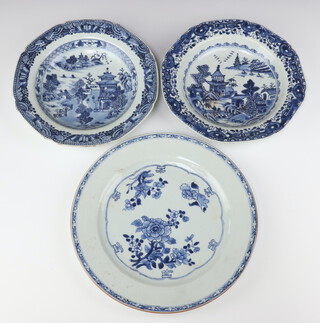 Two Chinese export blue and white shallow bowls, Qing dynasty, Qianlong period, painted with retreats in a river landscape together with a blue & white plate painted with flowers 23.7cm and 27cm diam (3)