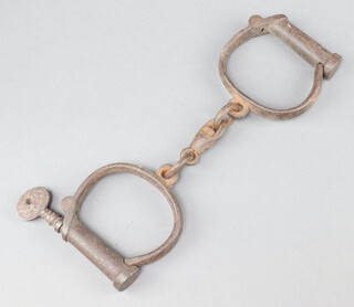 A pair of 19th Century iron handcuffs complete with key marked 4Hiatt 