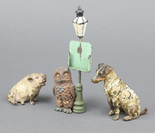 A bronze cold painted figure of a seated terrier 8cm (some paint loss) and ditto pig 5cm, together with a metal figure of an owl by a street lamp 5cm 