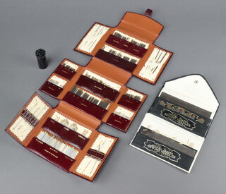 A Cranberry pin case containing various sewing needles in a red leather needle case together with a black and white silk needle wallet containing needles  