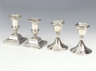 A pair of Edwardian design silver dwarf candlesticks on square bases, rubbed marks, 10cm and a ditto pair with waisted stems, Birmingham 1929 9.5cm 