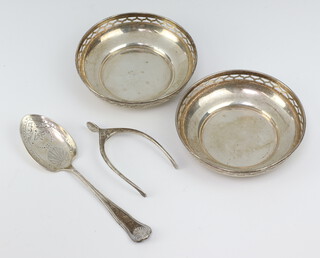 A pair of silver wishbone sugar nips Birmingham 1913, 2 nut dishes and a preserve spoon 195 grams 