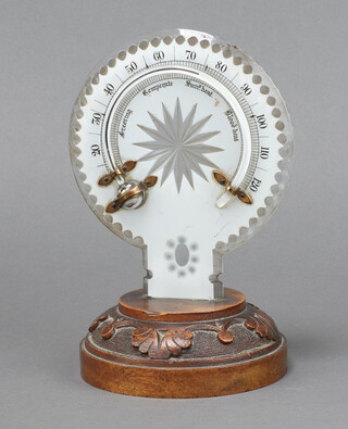 A 19th Century shaped and cut glass thermometer raised on a carved mahogany base 20cm x 12cm 