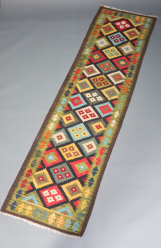 A black, green and orange ground Maimana Kilim runner with geometric design 297cm x 82cm 