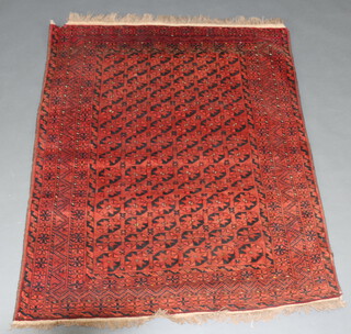 A red and black ground Afghan rug with 84 octagons to the centre within a multi row border 163cm x 135cm 