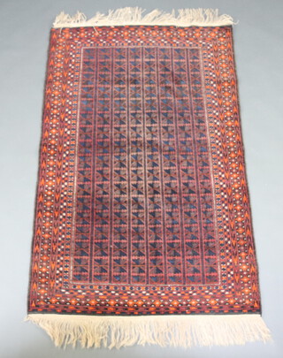 A blue, black, red and orange ground Belouche rug with central field formed of squares within a multi row border 184cm x 120cm 