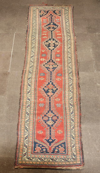 A tan, blue and green ground Caucasian runner with 5 stylised hooked diamonds to the centre within a multi row border 362cm x 97cm 