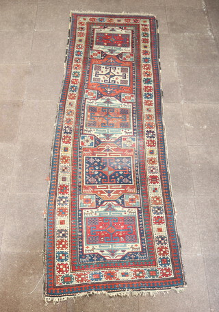 A blue, tan and white ground Caucasian runner with 5 stylised rectangular panels to the centre within a multi row border 304cm x 98cm  