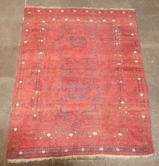 A red and white ground Afghan rug with 2 stylised medallions to the centre within a multi row border 215cm x 157cm 