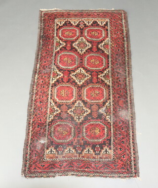 A red, black and white ground Belouche rug with 8 octagons to the centre within a multi row border 176cm x 94cm 