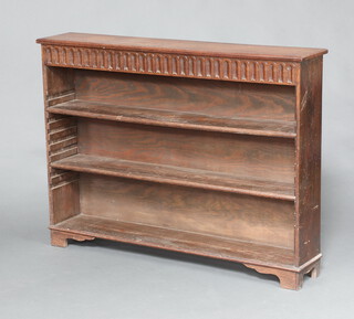 An Ipswich style bleached oak bookcase with arcaded decoration fitted adjustable shelves, raised on bracket feet 90cm h x 121cm w x 23cm d 