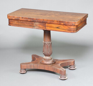 A William IV rosewood D shaped card table raised on a turned column and triform base ending in bun feet, 76cm h x 91cm w x 45cm d 