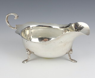 An Edwardian silver sauce boat with cut rim, scroll handle and paw feet, Chester 1906, 146 grams