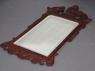 A Victorian arched bevelled plate wall mirror contained in a heavily carved frame with scallop and grape decoration 126cm x 65cm 