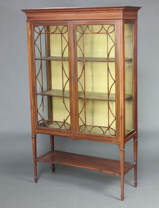 An Edwardian inlaid mahogany display cabinet with moulded cornice, fitted shelves enclosed by astragal style glazed panelled doors with undertier, raised on square tapered supports, spade feet  173cm h x 107cm w x 40cm d 