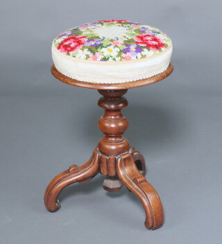 A Victorian carved oak adjustable piano stool with floral Berlin woolwork seat, raised on a bobbin turned column and tripod base 55cm h x 35cm diam. 