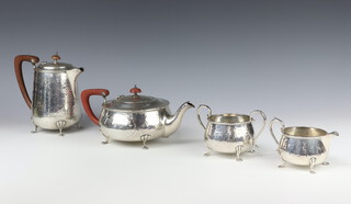 An Arts and Crafts style silver hammer patterned 4 piece tea and coffee and set comprising teapot, coffee pot, milk jug and sugar bowl, on pad feet, by J B Chatterley and Sons, Birmingham 1927, gross weight 2026 grams  