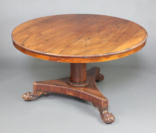 A William IV circular snap top rosewood breakfast table raised on a turned column and triform base with paw feet 71cm h x 128cm diam.  