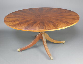 A circular Georgian style mahogany and figured walnut breakfast table raised on a pillar and tripod base ending in brass caps and casters 76cm h x 153cm diam. 