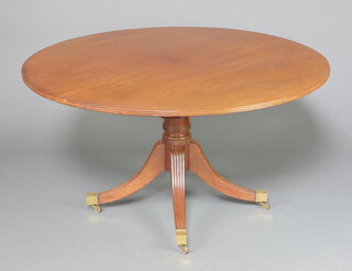 A 19th Century circular bleached mahogany breakfast table raised on a turned column and tripod base ending in brass caps and casters 71cm h x 135cm diam. 