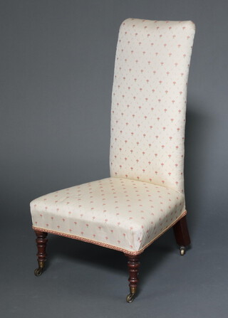 A Victorian nursing chair upholstered in white and floral material, raised on turned supports, brass cap and casters 100cm h x 55cm w x 53cm d 