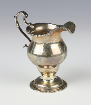 A Georgian silver cream jug with egg and dart ring and carved armorial, 110 grams, 9.5cm, rubbed marks 