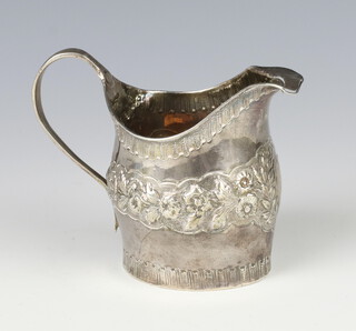 A William IV repousse silver cream jug with engraved armorial and floral decoration 117 grams, 10cm 