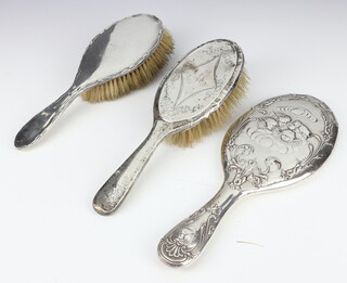 An Edwardian silver backed hand mirror with Reynolds angels decoration Birmingham 1901, 2 silver backed brushes 