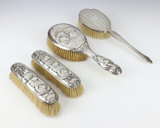 An Edwardian silver backed hair brush and 2 clothes brushes with Reynolds angels decoration, London 1909 and an engine turned hair brush 