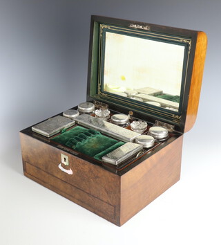 A Victorian walnut dome topped toilet box containing 8 silver plated mounted bottles and 2 glass jars with base drawer 