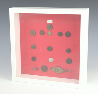 A collection of 12 Roman bronze coins and artefacts, framed, 