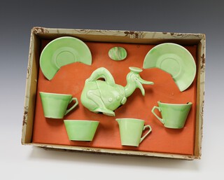 A  Wade Heath Donald Duck 7 piece green glazed dolls tea service comprising teapot (lid chipped), 2 cups (1 cracked), 2 saucers (1 cracked), cream jug (cracked and repaired), sugar bowl (cracked), boxed 