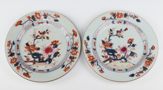 A pair of Chinese export rose Imari plates, Qing dynasty, Qianlong period, each painted with peony amongst rockwork, 22.87cm diameter