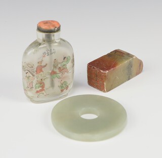 A circular green hardstone panel 5cm, a hardstone seal 5cm and an interior painted snuff bottle decorated figures 6cm 