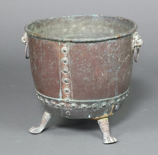 A circular copper and brass twin handled planter with ring mask handles, raised on paw feet 40cm h x 43cm diam. (1 foot stuck on)