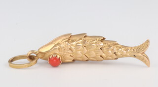 A yellow metal stamped 18 articulated fish pendant with coral eyes 5.7 grams, 40mm 