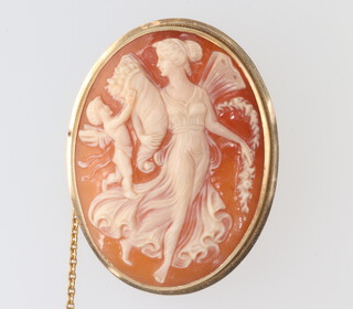 A yellow metal stamped 14k oval cameo brooch decorated with a lady and cherub 