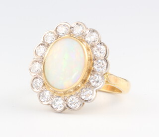 An 18ct yellow gold oval opal and diamond cluster ring, the opal 12mm x 10mm, the 14 brilliant cut diamonds each approx. 0.07ct, gross weight 8.6 grams, size L 