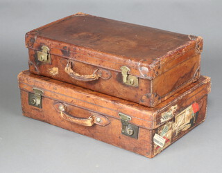 A 1930's leather suitcase with brass mounts 18cm x 66cm x 37cm and 1 other the locks marked DM Touche Westcott Dorking applied luggage labels 19cm h x 71cm w x 45cm d 